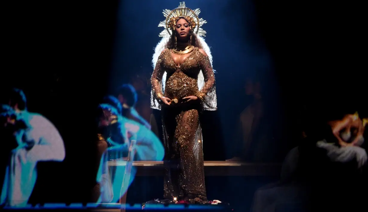 Penyanyi Beyonce memberikan penampilan memukau di atas panggung Grammy Awards 2017 di Staples Center, Los Angeles, Minggu (12/2). Di acara penghargaan itu, Beyonce terlihat megah bak dewi dengan kostum serba emas. (Kevin Winter/Getty Images for NARAS/AFP)