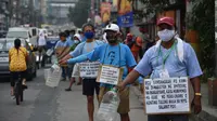 Pengemudi jeepney dengan poster “Bu / Pak, kami pengemudi jeepney, mohon bantuannya”, di sepanjang jalan di Manila, 12 Agustus 2020. Angkutan ikonik di Filipina itu belum dapat mengangkut penumpang sejak Maret akibat lockdown Covid-19 yang membuat jutaan orang kehilangan pekerjaan. (Ted ALJIBE/AFP)