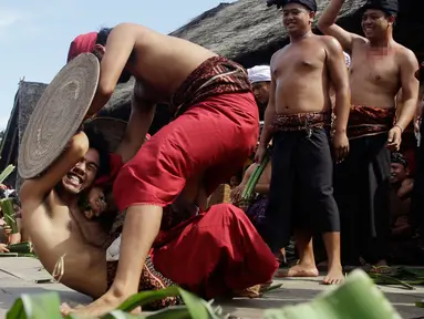Dua orang laki-laki saling serang saat mengikuti Perang Pandan di Bali (8/6). Perang pandan adalah salah satu tradisi yang ada di Bali. Perang ini hanya boleh diikuti oleh kaum pria yang mulai menginjak usia dewasa. (AP/Firdia Lisnawati)
