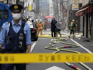 Petugas pemadam kebakaran dan polisi bekerja di lokasi ledakan di sebuah gedung di Tokyo, Jepang, Senin (3/7/2023). Sebanyak empat orang terluka akibat kejadian tersebut. (AP Photo/Eugene Hoshiko)