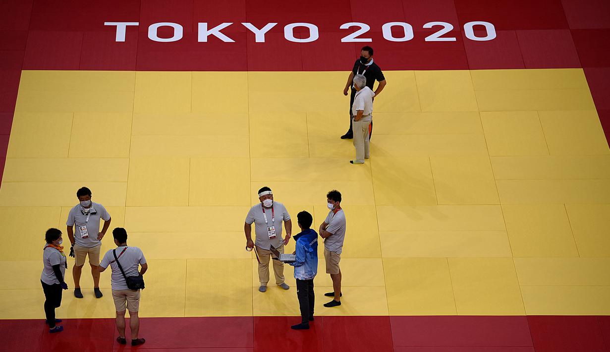 Para juri, relawan, dan teknisi bekerja di dalam venue Nippon Budokan untuk pertandingan judo dan karate selama Olimpiade Tokyo 2020 di Tokyo pada 21 Juli 2021. (AFP/Franck Fife)