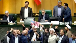 Anggota parlemen Iran bersiap membakar dua lembar kertas bergambar bendera AS, Teheran, Iran, Rabu (9/5). Anggota parlemen Iran juga meneriakkan slogan-slogan menentang AS. (AP Photo)