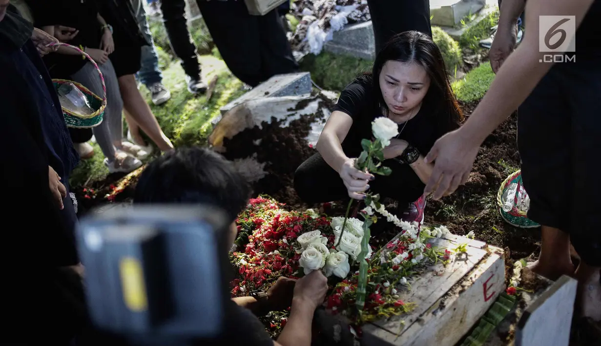 Kekasih almarhum Andika Putra Sahadewa, Nicky Santoso menaruh mawar di makam di TPU Sunan Giri, Rawamangun, Jakarta, Selasa (10/9). Bassist grup band Kerispatih, Andika Putra Sahadewa, meninggal dunia di usia 36 tahun. (Liputan6.com/Faizal Fanani)