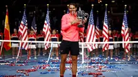 Rafael Nadal memegang trofi AS Terbuka 2017 setelah mengalahkan Kevin Anderson di final, Minggu (10/9/2017) waktu setempat. (AP Photo/Peter Morgan)