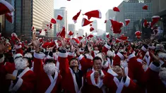 Sejumlah orang berpakaian seperti Santa Claus membuang topi mereka ke udara selama acara amal Natal di pusat kota Seoul, Korea Selatan, (24/12/2015). (REUTERS/Kim Hong-Ji)