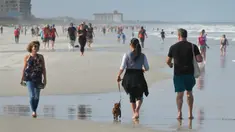 Warga berjalan di pantai selama pandemi Covid-19 di Jacksonville Beach, Florida (17/4/2020). Gubernur Ron DeSantis memberikan lampu hijau beberapa pantai dan taman untuk dibuka kembali jika dapat dilakukan dengan aman setelah ditutup karena Covid-19.  (Will Dickey/The Florida Times-Union via AP)
