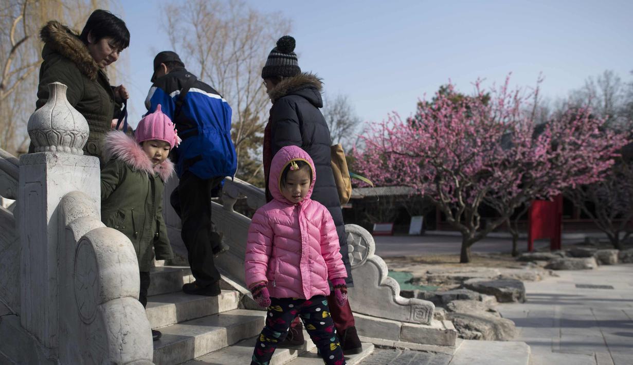 Warga berjalan di sebuah jembatan di Ditan Park di Beijing (1/2). Tahun Baru Imlek jatuh pada 16 Februari tahun ini, dengan perayaan yang berlangsung selama seminggu di China. (AFP Photo/Nicolas Asfouri)