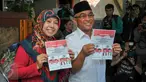 Mohammad Idris dan istri memegang surat suara sebelum melakukan pencoblosan di TPS 077 di Perum Pondok Duta, Depok, (9/12). Idris akan bersaing dengan pasangan nomor urut satu yaitu Dimas Oky Nugroho dan Babai Suhaimi. (Liputan6.com/Yoppy Renato)