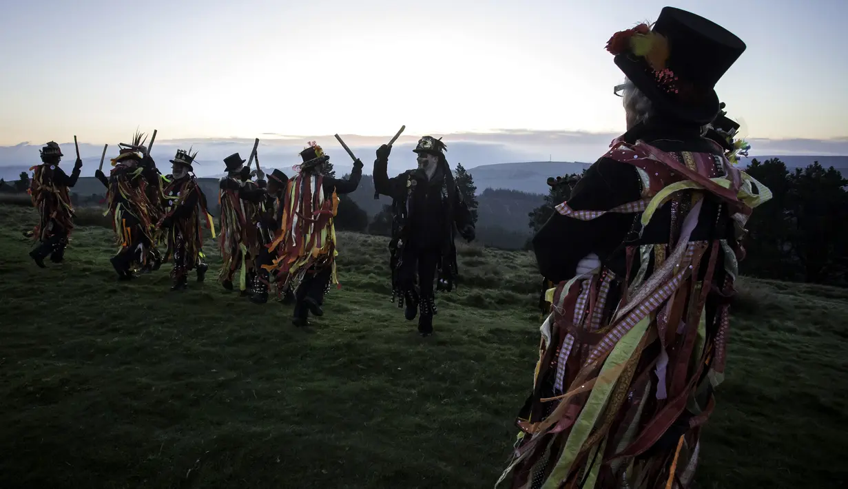 Anggota Powderkeg Morris Dancers menari di atas Windgather Rocks di High Peak di Derbyshire sebelum matahari terbit (1/5). Mereka melakukan tarian tahunan sebagai bagian dari festival Celtic kuno. (AFP Photo/Lindsey Parnaby)