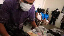 Petugas menata barang bukti pada gelar perkara kasus narkoba di BNNP DIY, Jumat (15/4/2016). Petugas berhasil mengamankan tujuh tersangka dan seorang WN Afrika dalam empat TKP yang berbeda. (Foto: Boy Harjanto)