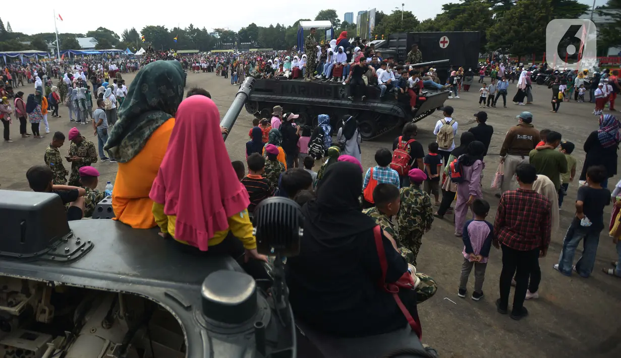 Warga naik tank berkeliling  di lapangan Marinir Cilandak, Jakarta, Selasa (15/11/2022). Kegiatan ini dilakukan dalam rangka peringatan HUT Ke-77 Korps Marinir dibuka untuk warga mencoba berkeliling markas Marinir. (merdeka.com/Imam Buhori)