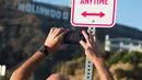 Seorang pria mengambil gambar rambu bertuliskan "No Trump Anytime" di jalan utama dekat Bukit Hollywood, California, Rabu (27/4). Rambu anti-Donald Trump itu terinspirasi dari berita dunia politik dan alat peraga kampanye Pilpres AS (Robyn BECK/AFP)