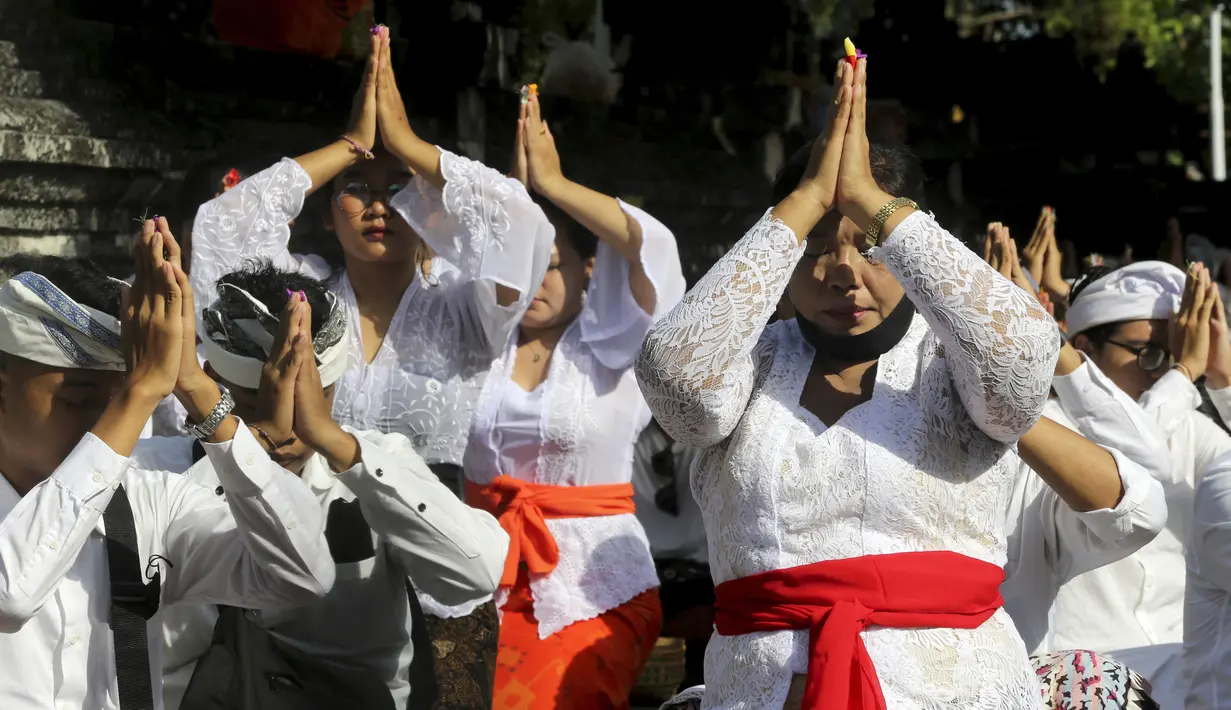 Umat Hindu Bali berdoa saat merayakan Hari Raya Kuningan di Pura Sakenan, Bali, Sabtu (18/6/2022). Kuningan menandai hari terakhir perayaan Galungan, salah satu upacara keagamaan terbesar umat Hindu di Bali. (AP Photo/Firdia Lisnawati)
