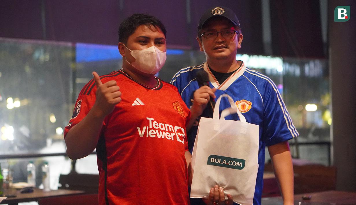 Seorang anggota komunitas United Army mendapatkan goodie bag setelah berhasil menjawab pertanyaan saat Roaring Night Liga Inggris 2023/2024 antara Manchester United versus Everton di Brewerkz, The Breeze BSD City, Tangerang, Sabtu (9/3/2024) malam WIB. (Bola.com/Afi)