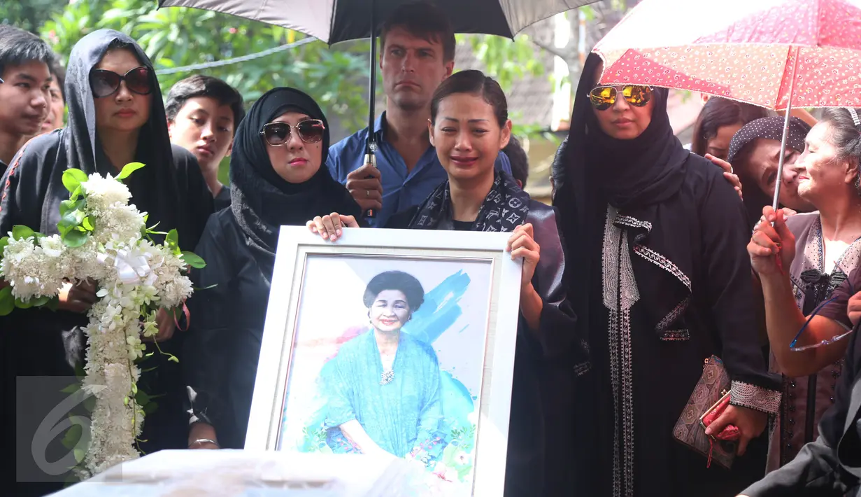 Tangis Indah Kalalo pecah saat mengantar jenazah sang bunda, Rose Suyadi Kalalo, ke TPU Menteng Pulo, Jakarta, Selasa (24/5). Indah Kalalo yang sembari memeluk foto, terlihat sesenggukan menatap peti jenazah ibundanya. (Liputan6.com/Herman Zakharia)