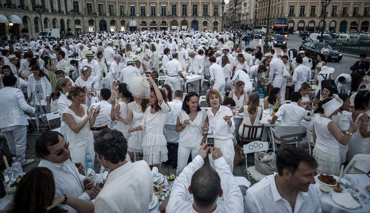 Keseruan peserta saat acara 'Diner en blanc' atau 'Makan Malam Putih' digelar di Place Vendome, Paris, Rabu (8/6). Acara ini digelar secara dadakan serta memanfaatkan teknologi internet dan jejaring sosial sebagai sarana publikasi.  (PHILIPPE LOPE/AFP)