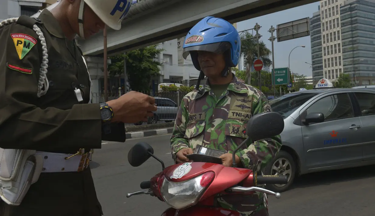 Personel Polisi Militer memeriksa kelengkapan surat-surat kendaraan milik anggota TNI AL ketika berlangsungnya Operasi Zebra 2014 di sekitar Pasar Senen, Jakarta, Rabu (26/11). (ANTARA FOTO/Saptono)