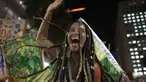 Seorang peserta pesta jalanan yang dikenal sebagai blocos, menari selama protes terhadap pembatasan oleh pejabat kota di Rio de Janeiro, Brasil (13/4/2022). Balai Kota telah melarang pesta jalanan selama perayaan Karnaval, yang tertunda hampir dua bulan karena pandemi. (AP Photo/Silvia Izquierdo)