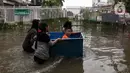 Warga melintasi banjir yang merendam kawasan Green Garden, Jakarta Barat, Selasa (25/2/2020). Hujan yang mengguyur kawasan Jakarta membuat kawasan tersebut tergenang banjir setinggi 60-80 cm. (Liputan6.com/Johan Tallo)