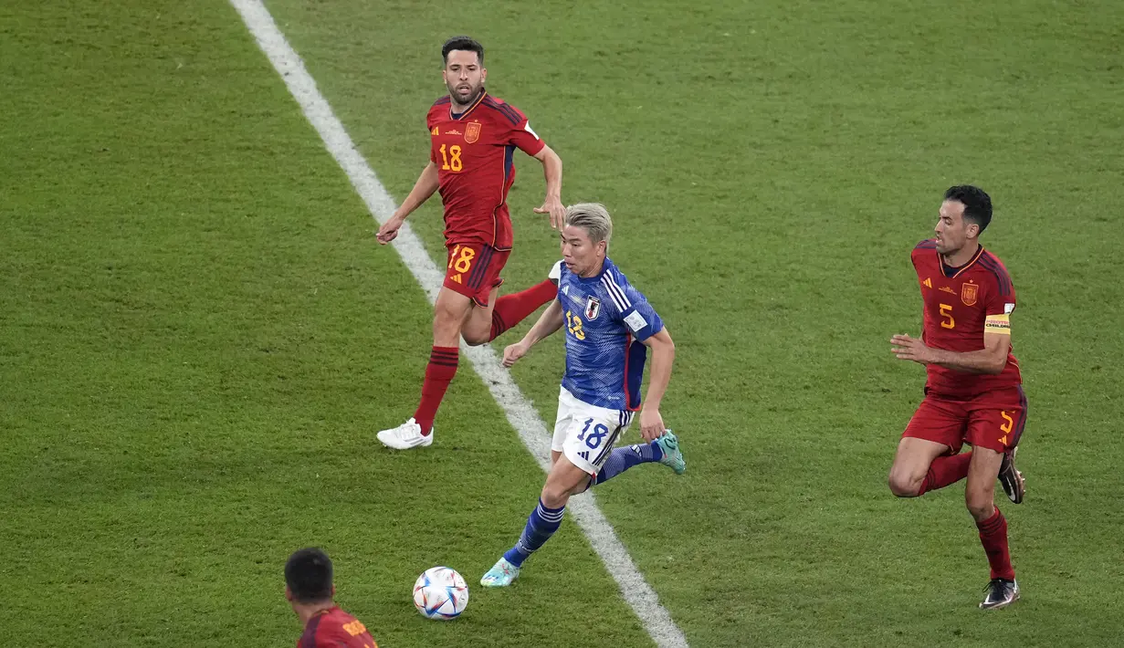 Penyerang Jepang, Takuma Asano membawa bola dari kawalan para pemain Spanyol selama pertandingan grup E Piala Dunia 2022 di Stadion Internasional Khalifa di Doha, Qatar, Jumat, 2 Desember 2022. Hasil ini membuat Jepang lolos ke babak 16 besar sebagai juara Grup E dengan enam poin. (AP Photo/Themba Hadebe)