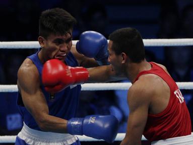 Petinju Indonesia, Farrand Papendang, beradu pukul dengan petinju Thailand, Khunatip Pidnuch, pada semifinal kelas 60 kg SEA Games 2019 di PICC Forum, Manila, Minggu (8/12). Farrand kalah dengan poin 139-146. (Bola.com/M Iqbal Ichsan)