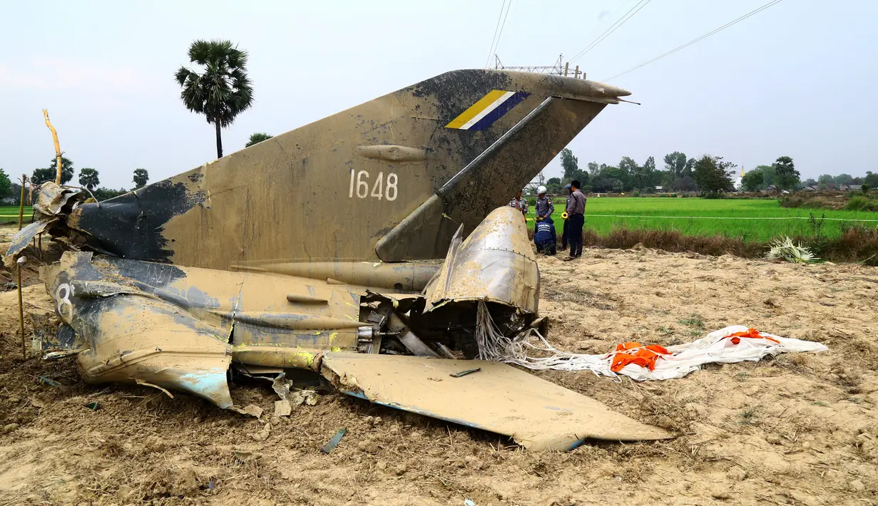 Reruntuhan jet tempur milik Myanmar jatuh di area persawahan desa Kyunkone yang berjarak satu jam dari ibu kota Naypyidaw, Selasa (3/4). Pilot pesawat jet tempur tersebut tewas karena lukanya saat dalam perjalanan ke rumah sakit militer. (AFP Photo)