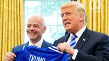 Presiden AS, Donald Trump, berpose dnegan jersey yang diberikan presiden FIFA, Gianni Infantino, selama pertemuan di Oval Office Gedung Putih, Selasa (28/8). Presiden FIFA bertemu Trump untuk membahas kesiapan Piala Dunia 2026. (AFP/Mandel Ngan)