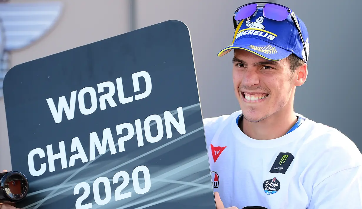 Pembalap Suzuki Ecstar, Joan Mir tersenyum saat merayakan Juara Dunia 2020 usai balapan di MotoGP Valencia di Sirkuit Ricardo Tormo di Valencia, Spanyol, Minggu (15/11/2020). (AFP/Lluis Gen)