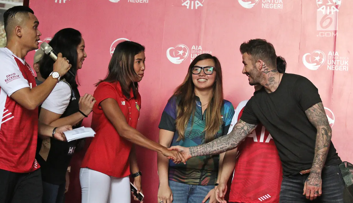 Atlet Asian Games Indonesia berjabat tangan dengan mantan bintang sepak bola Inggris David Beckham pada acara AIA Sepak Bola untuk Negeri di Jakarta, Minggu (25/3). (Liputan6.com/Herman Zakharia)