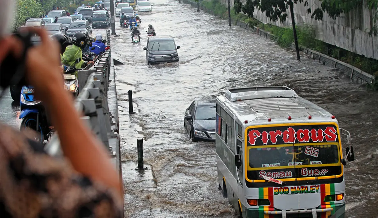 Sebuah Kopaja nekat menerobos banjir di Jl.Pemuda, Taman Ria Senayan, Jakarta, Jumat (30/5/2014) (Liputan6.com/Faizal Fanani)