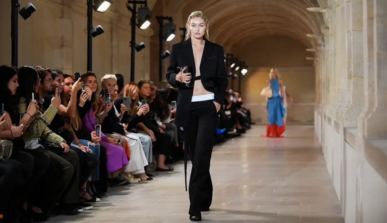 Model AS Gigi Hadid mempersembahkan kreasi untuk peragaan busana Victoria Beckham Spring-Summer 2023 pada Paris Womenswear Fashion Week di Paris, Prancis, 30 September 2022. Gigi tampil seksi tanpa bra saat menampilkan busana karya Victoria Beckham di Paris Fashion Week. (JULIEN DE ROSA/AFP)