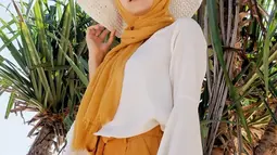 Saat liburan, Ellen tampil dengan hijab panjang berwarna oranye dipadukan dengan celana panjang berwarna seragam dan baju berwarna putih. (Liputan6.com/IG/@ellennitaa)