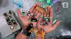 Petugas UPS Badan Air DLH Provinsi DKI Jakarta, Bang Timan menunjukkan miniatur kendaraan yang terbuat dari limbah korek api di Jakarta, Kamis (3/8/2023). Sisi lain Bang Timan adalah beliau dikenal dengan kemampuannya mengubah limbah korek api untuk dijadikan kerajinan tangan yang menarik. (Liputan6.com/Johan Tallo)