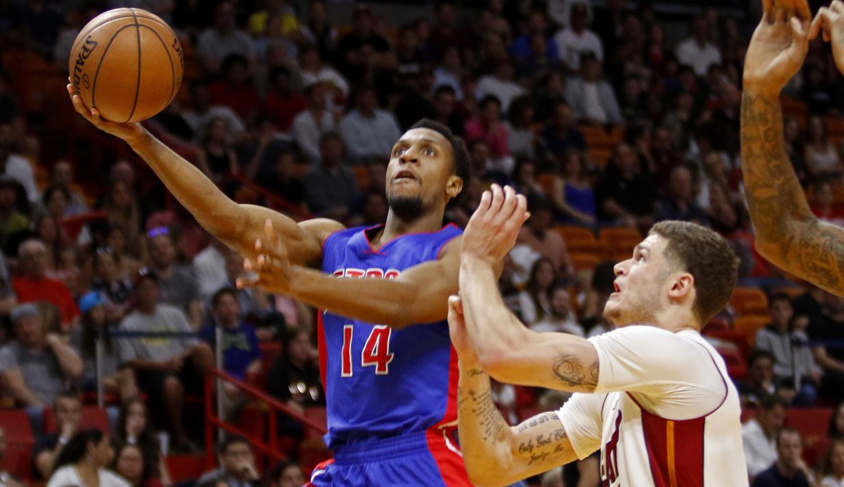 Pemain Detroit Pistons Ish Smith (kiri) melakukan tembakan melewati hadangan pemain Miami Heat, Tyler Johnson (kanan) pada laga NBA di American Airlines Arena, Miami, (01/01/2017). Pistons menang 107-98. (AP/Joe Skipper)
