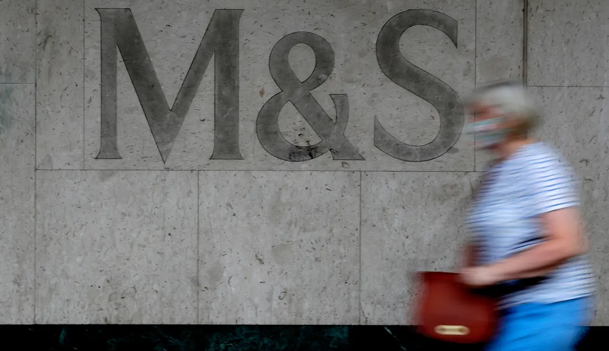 Seorang perempuan melewati tanda di cabang toko Marks and Spencer di London, Selasa (18/8/2020). Peretail Inggris, Marks & Spencer pada Selasa (18/8) mengumumkan rencananya untuk memangkas 7.000 pekerja dalam tiga bulan ke depan di tengah pandemi COVID-19. (AP Photo/Kirsty Wigglesworth)