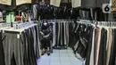 Pedagang menunggu pembeli pakaian bekas impor di Pasar Senen, Jakarta, Kamis (4/3/2021). Sepinya penjualan diperparah dengan rumor pakaian bekas impor berpotensi menyebarkan virus COVID-19. (merdeka.com/Iqbal S. Nugroho)