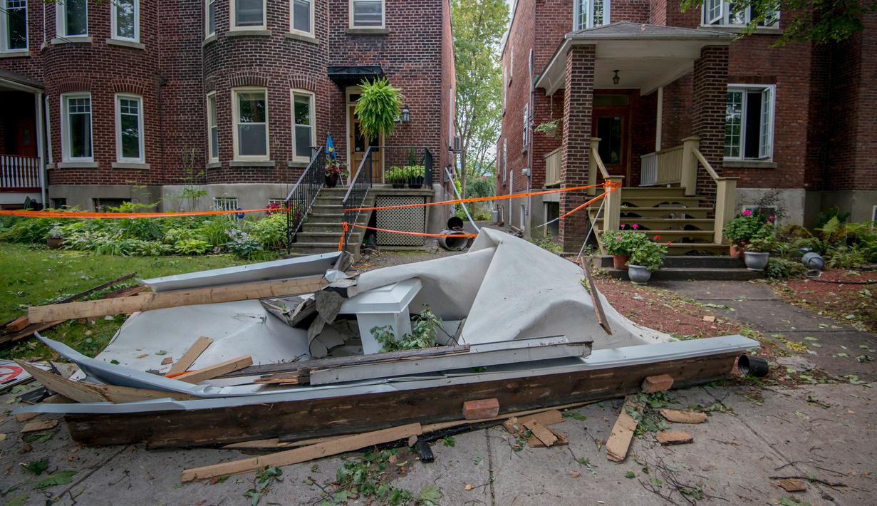 Atap sisa reruntuhan bagunan tergeletak di sisi jalan wilayah Montreal Notre-Dame-de-Grace, Quebec, Rabu (23/8). Sekitar 310 hunian mengalami kerusakan dan lebih dari 63.000 pelanggan mengalami pemadaman listrik. (Peter McCabe/The Canadian Press via AP)