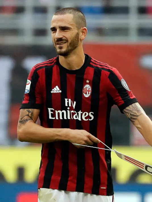 Bek AC Milan, Leonardo Bonucci melepas ban kapten setelah menerima kartu merah dari wasit Piero Giacomelli saat melawan Genoa pada Liga Italia di San Siro, Milan (22/10). Bonucci mendapat kartu merah usai menyikut Aleandro Rosi. (AP Photo/Luca Bruno)