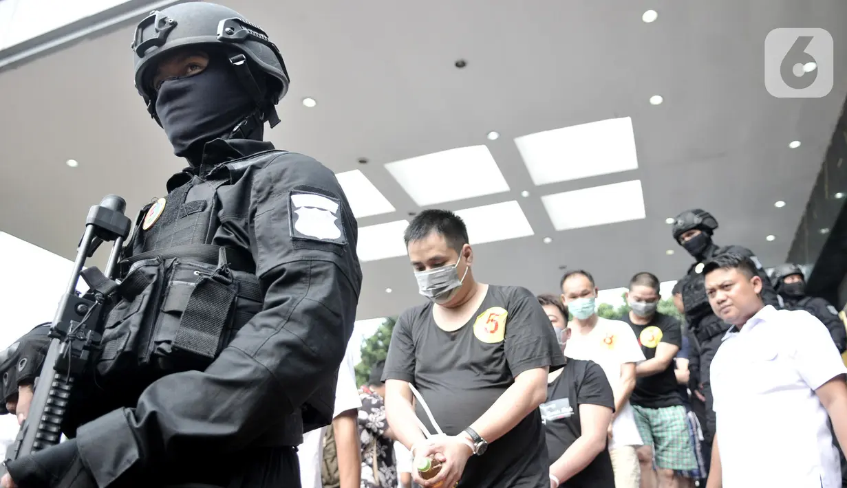 Polisi menggiring para tersangka kasus penipuan online (Telecom Fraud) di Mapolda Metro Jaya, Jakarta, Selasa (26/11/2019). Polisi menyita sejumlah barang bukti dalam penggerebekan di enam lokasi di Jakarta Barat. (merdeka.com/Iqbal Nugroho)