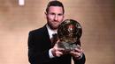 Saat meraih trofi Ballon d'Or untuk yang keenam kalinya pada 2019 masih bersama Barcelona, Lionel Messi tampil beda dibandingkan dengan lima penghargaan sebelumnya. La Pulga mulai memelihara kumis dan berewoknya saat berpose dengan trofi Ballon d'Or 2019. (AFP/Franck Fife)