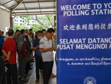 Warga Singapura tiba untuk memberikan suara di tempat pemungutan suara untuk pemilihan presiden (pilpres) Singapura, Jumat (1/9/2023). (Roslan RAHMAN / AFP)