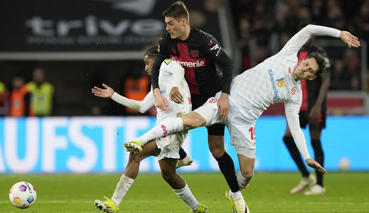 Pemain Bayer Leverkusen, Patrik Schick, berusaha melewati pemain Mainz dalam duel pekan ke-23 Bundesliga di Stadion BayArena, Sabtu (24/2/2024). (AP Photo/Martin Meissner)