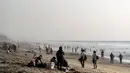 Orang-orang mengunjungi pantai di Playas de Tijuana dekat perbatasan AS-Meksiko di Tijuana Meksiko, Sabtu (3/10/2020). Akhir pekan ini pantai di Playas de Tijuana dibuka kembali dengan pembatasan pengunjung, setelah ditutup sejak Maret lalu guna mencegah penyebaran Covid-19. (Guillermo Arias/AFP)