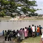 Warga menyaksikan proses evakuasi perahu terbalik di Bengawan Solo. (Ahmad Adirin/Liputan6.com)