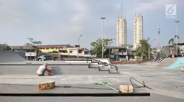 Pekerja melakukan pengecatan arena skate di RPTRA Kalijodo, Jakarta, Selasa (6/6). Untuk menjaga kenyamanan saat bermain, arena skatepark RPTRA kalijodo yang rusak diperbaiki. (Liputan6.com/Yoppy Renato)