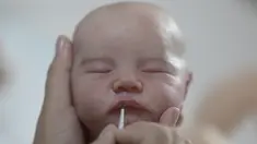 Seniman Brasil Ana Paula Guimaraes mengerjakan boneka bayi super realistis di studionya di Contagem, pada 16 November 2021. Boneka bernama Reborn Babies ini menampilkan detail seperti kuku, bulu mata, urat, lipatan, dan bintik-bintik di tubuh yang terlihat seperti bayi sungguhan. (DOUGLAS MAGNO/AFP)