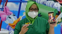 Perawat Irma Afrianti (34) menunjukkan foto anaknya saat di RSUD Pasar Minggu, Jakarta, Jumat (22/5/2020). Irma Afrianti sudah 2 bulan tidak bertemu keluarga selama bertugas menjaga COVID -19 di RSUD Pasar Minggu. (Liputan6.com/Herman Zakharia)