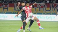 Bek Persebaya, Yan Victor mencoba menggangu pergerakan penyerang Persis Solo, Ramadhan Sananta dalam laga lanjutan BRI Liga 1 2023/2024 di Stadion Gelora Bung Tomo, Surabaya, Rabu (13/12/2023) malam WIB. (Bola.com/Aditya Wany)