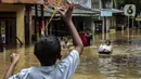 Anak-anak menyusuri banjir yang melanda Jalan Bina Warga Rt 005/Rw 07 Kelurahan Rawa Jati, Jakarta, Senin (8/2/2021). Banjir setinggi 60-190 cm tersebut disebabkan oleh luapan air Sungai Ciliwung dan curah hujan Jakarta yang tinggi. (Liputan6.com/Johan Tallo)