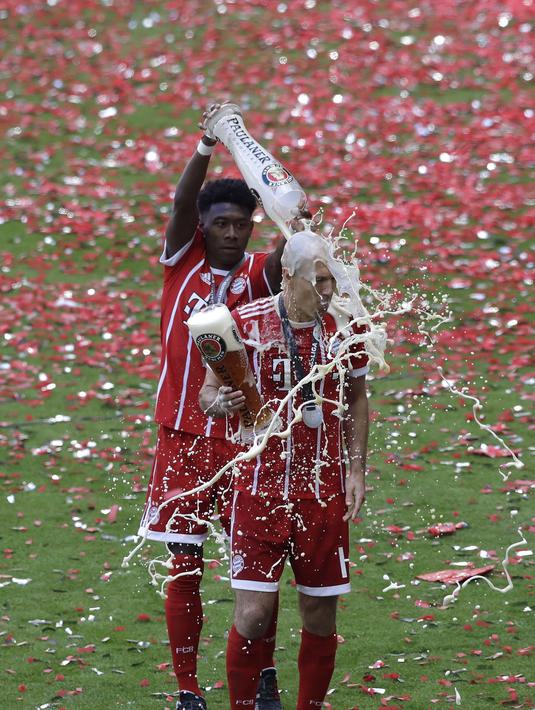 Arjen Robben terkena siraman bir oleh rekannya David Alaba saat perayahan penyerahan trofi juara Bundesliga di Allianz Arena stadium, Munich, (20/5/2017).  Bayern menang 4-1. (AP/Matthias Schrader)
